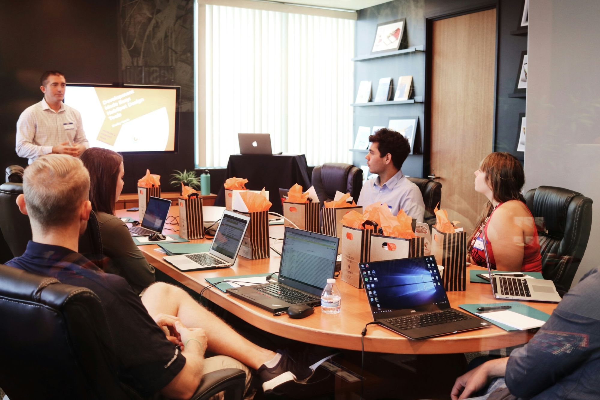 A conference room with laptops on a long table